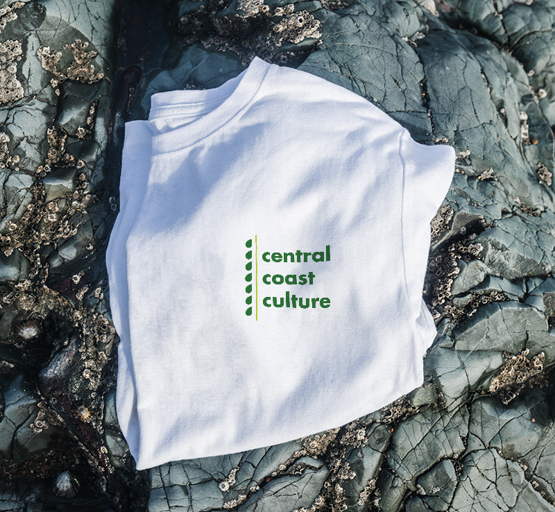 A folded white t-shirt decorated with the phrase “Central Coast Culture” and a vine graphic.