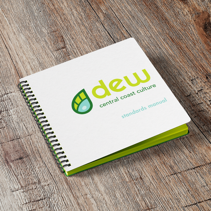 A spiral-bound book titled “Dew Standards Manual” on a wooden table.